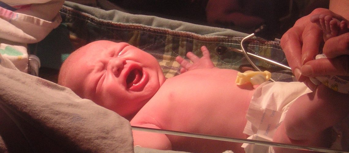 newborn-infant-being-weighed-1502375